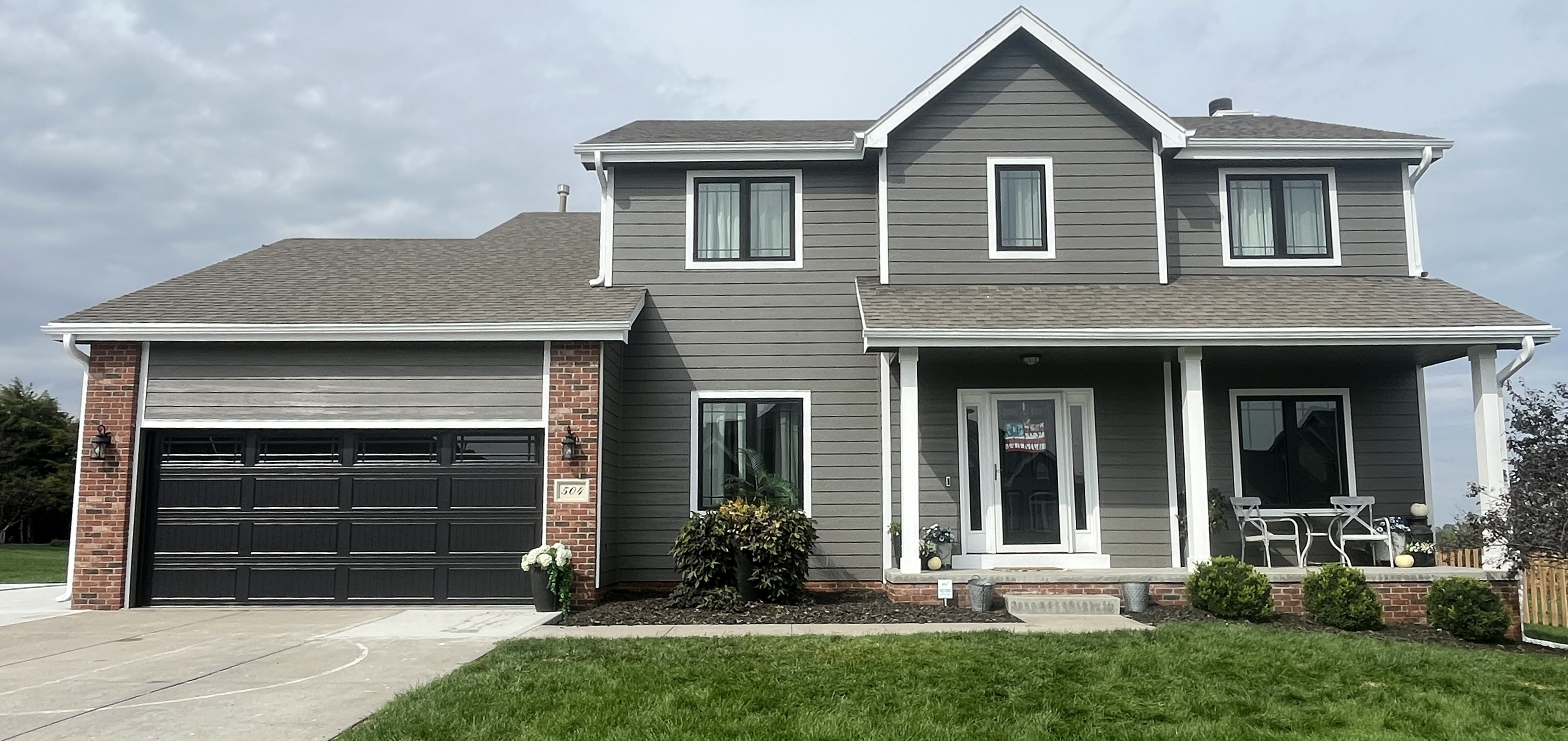 Gray two-story home with fresh trim and a repainted front porch
